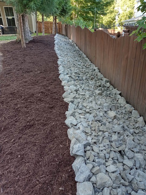 Drainage rock installation by KEEN alongside mulch bed